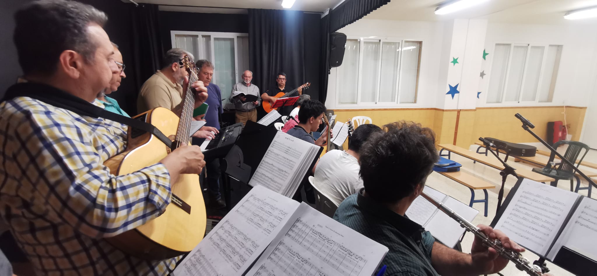 Guitarras, flauta y atriles con partituras en un ensayo del grupo